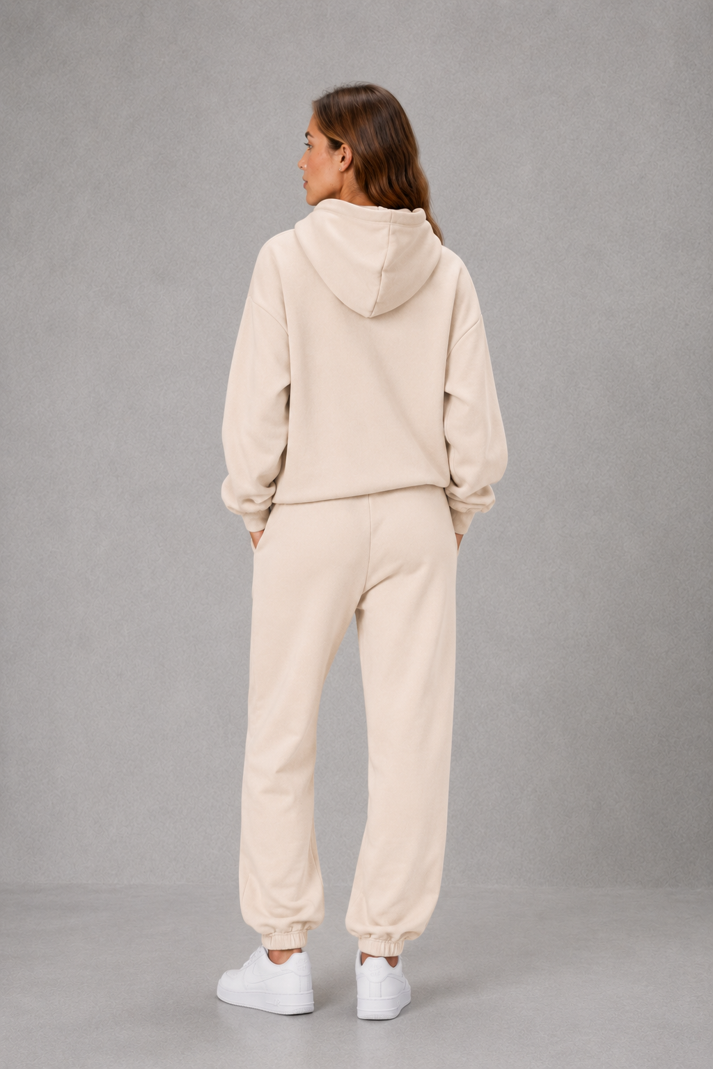 Women’s two-piece tracksuit set featuring a relaxed drawstring hoodie with front pocket and matching tapered jogger pants with cuffed ankles.