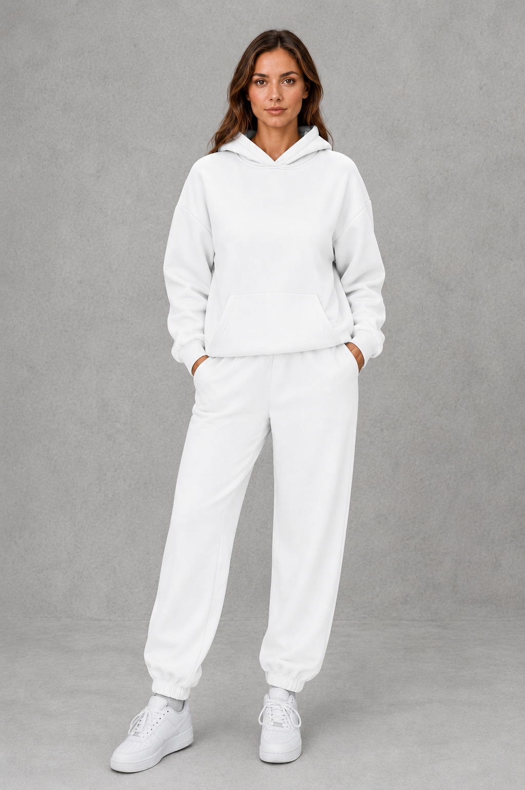 Women’s two-piece tracksuit set featuring a relaxed drawstring hoodie with front pocket and matching tapered jogger pants with cuffed ankles.