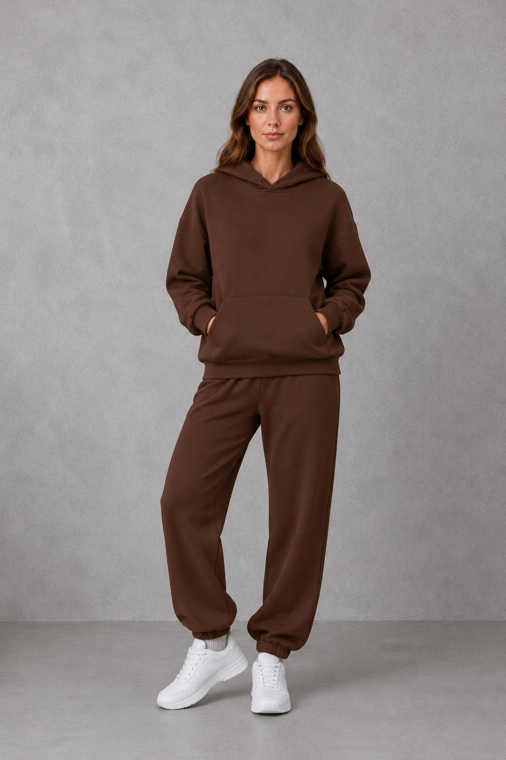 Women’s two-piece tracksuit set featuring a relaxed drawstring hoodie with front pocket and matching tapered jogger pants with cuffed ankles.