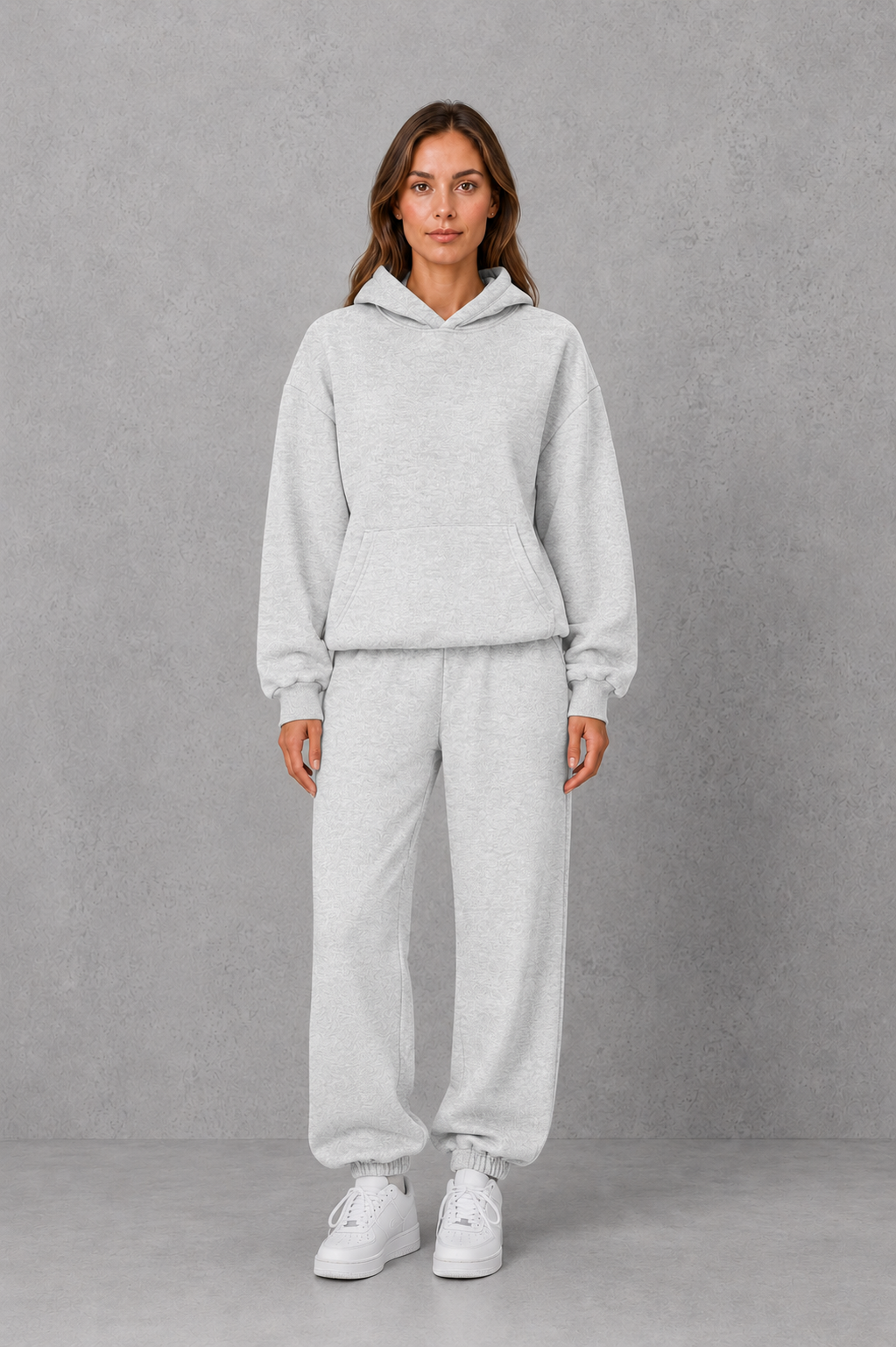Women’s two-piece tracksuit set featuring a relaxed drawstring hoodie with front pocket and matching tapered jogger pants with cuffed ankles.