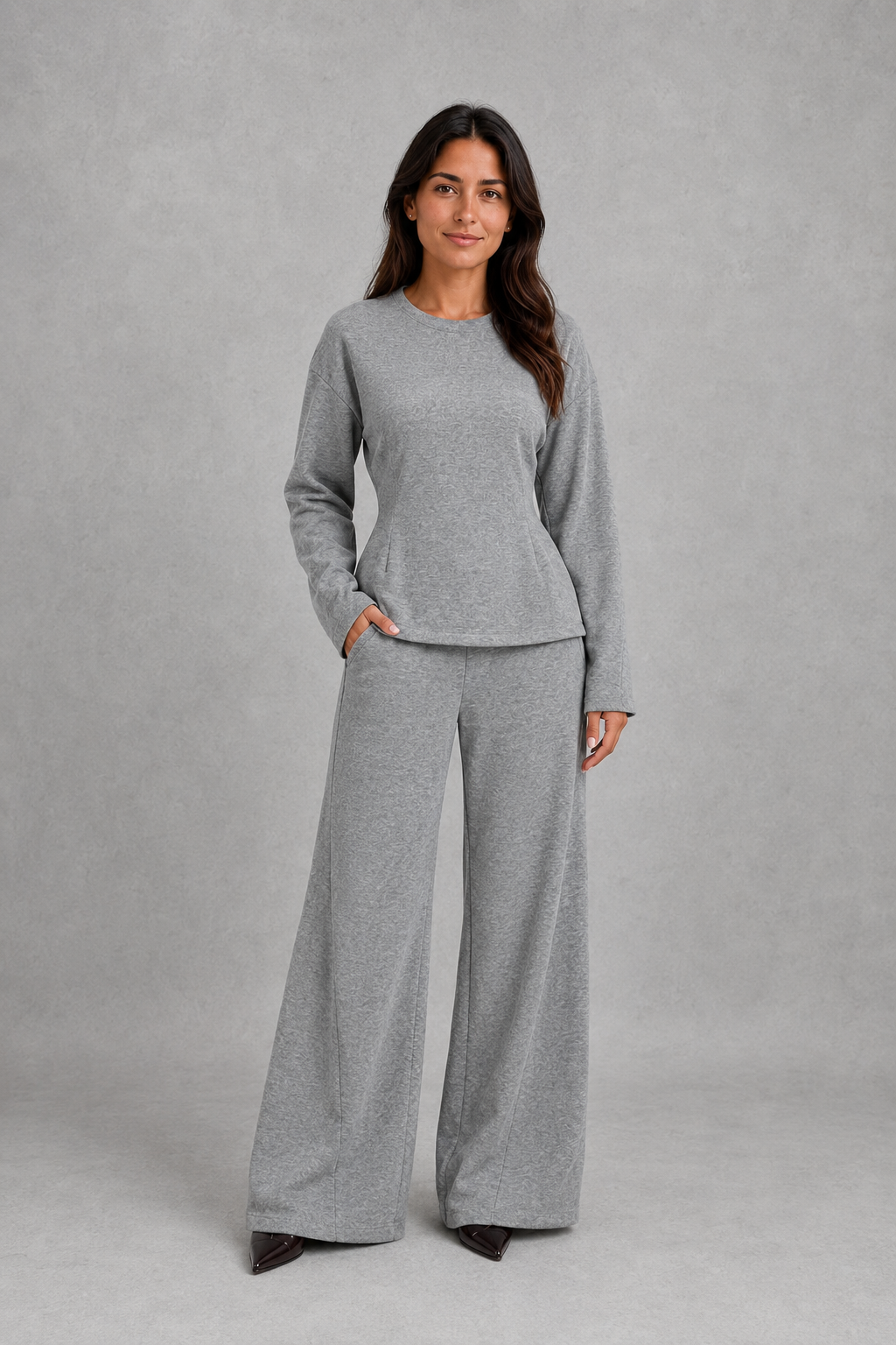 Women’s two-piece lounge set featuring a softly fitted long-sleeve crew neck top with a shaped waist and matching wide-leg pants with side pockets.