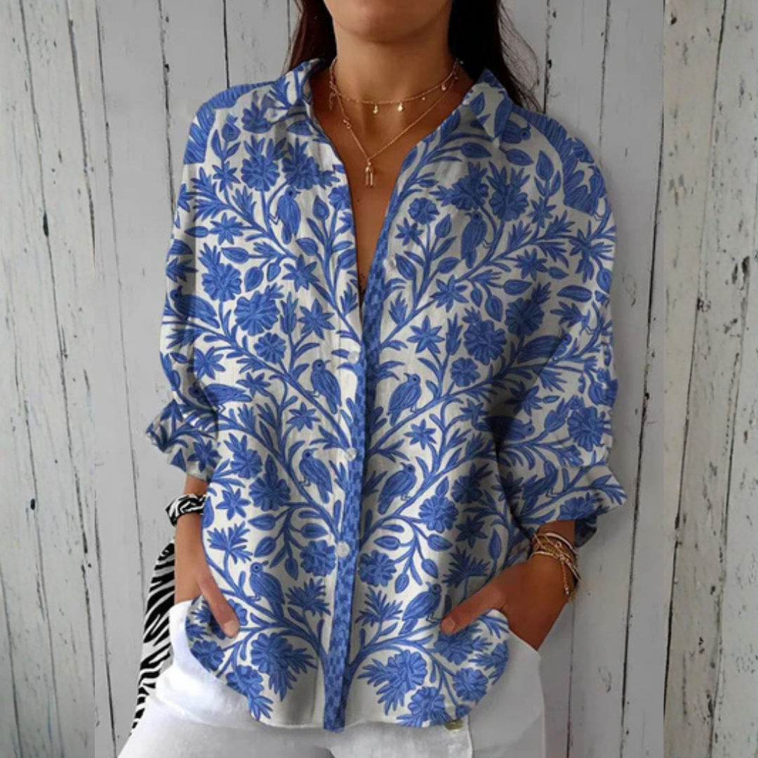 Women wearing a cream blouse with blue floral and bird print