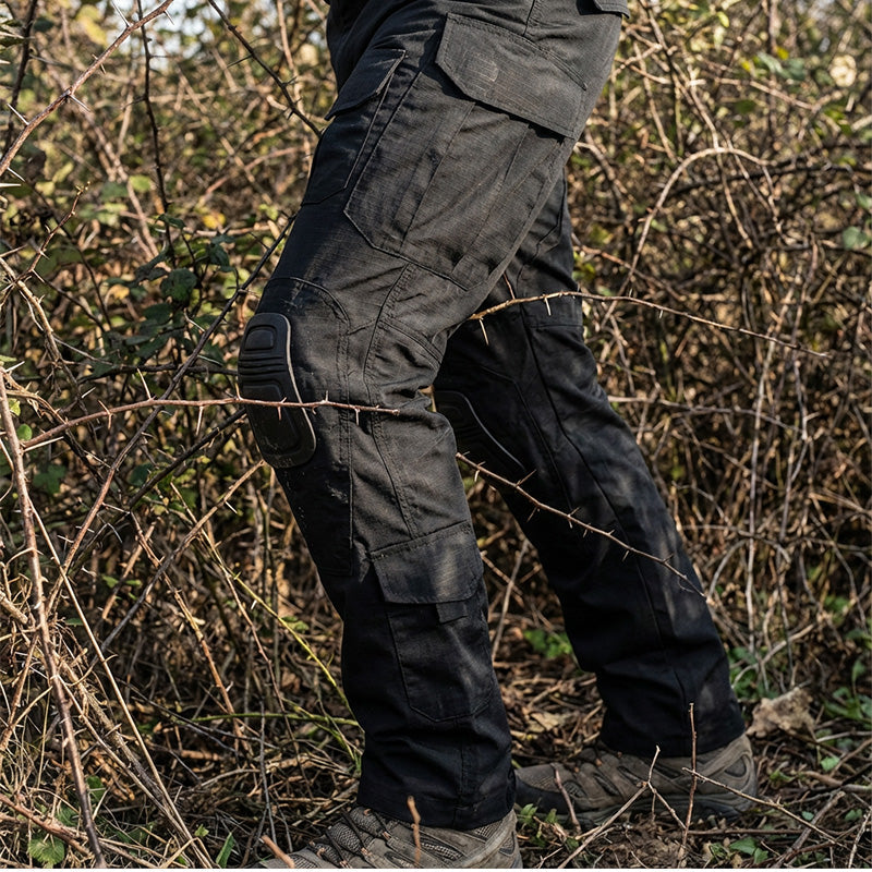 Men’s tactical cargo pants with integrated knee pads, adjustable straps, multiple pockets, and durable cotton-polyester fabric for outdoor work and rugged activities.