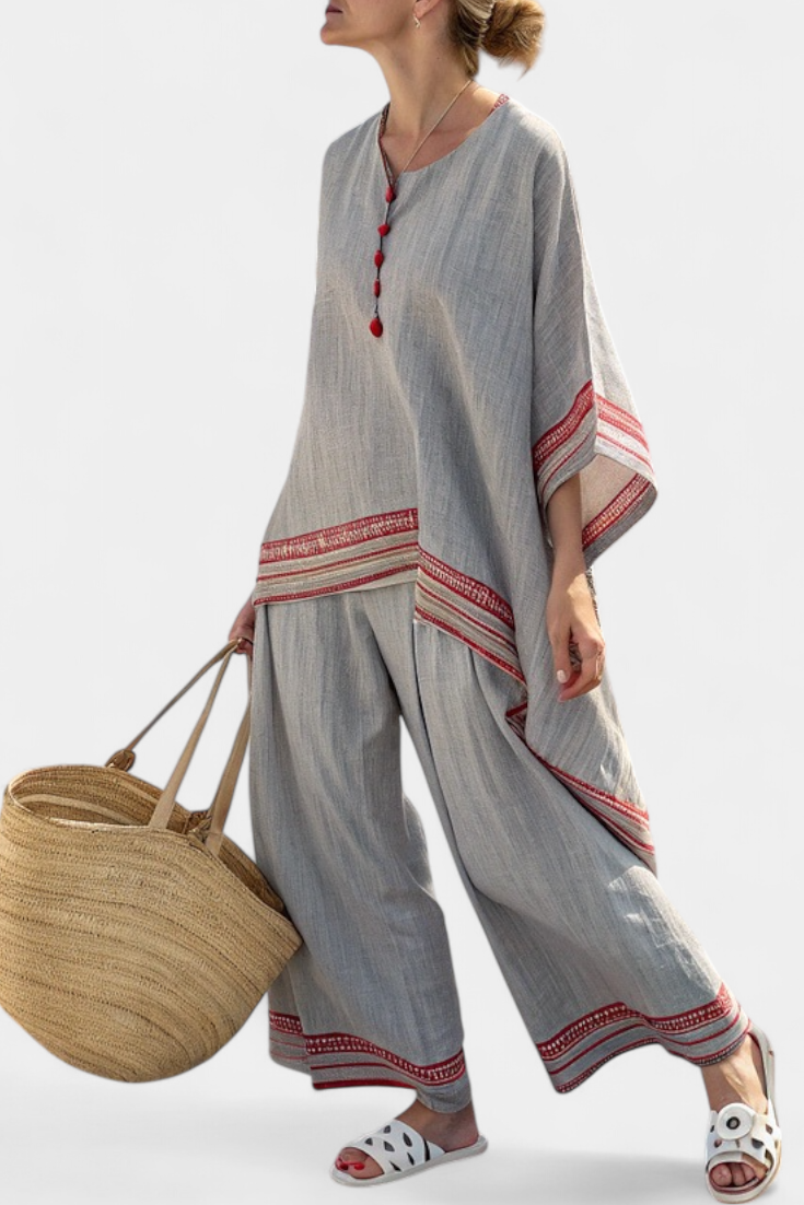 Women’s two-piece outfit featuring an asymmetrical blouse with embroidery and relaxed wide-leg pants designed for lightweight summer wear.