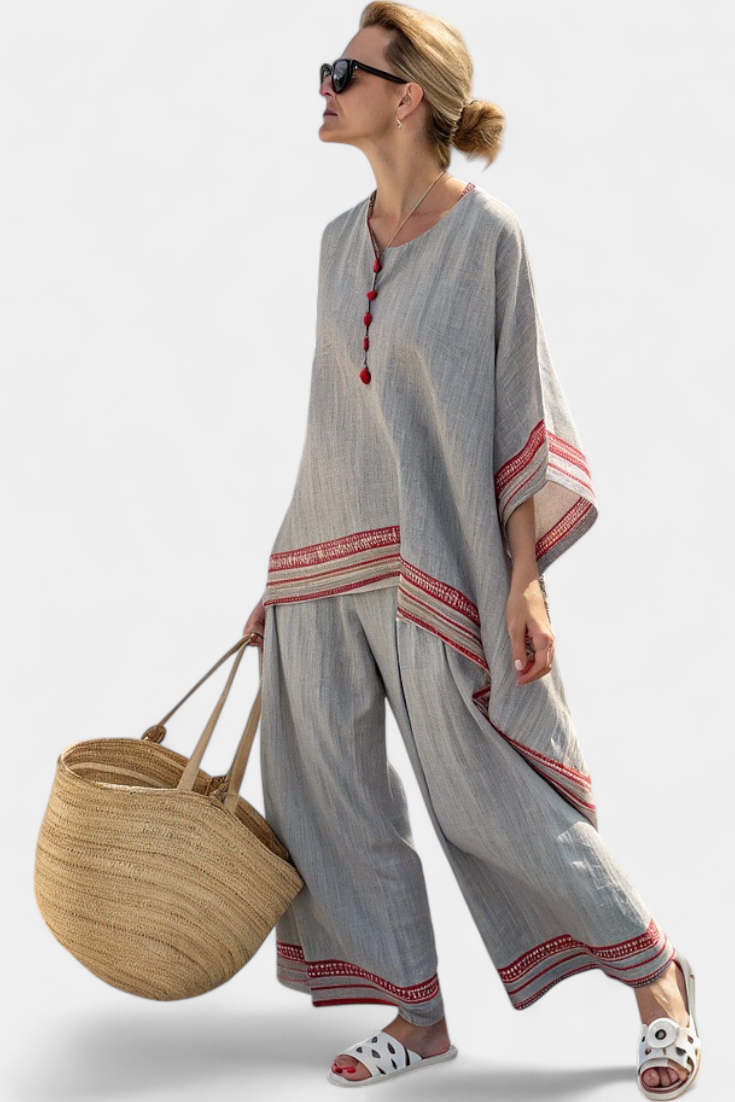 Women’s two-piece outfit featuring an asymmetrical blouse with embroidery and relaxed wide-leg pants designed for lightweight summer wear.