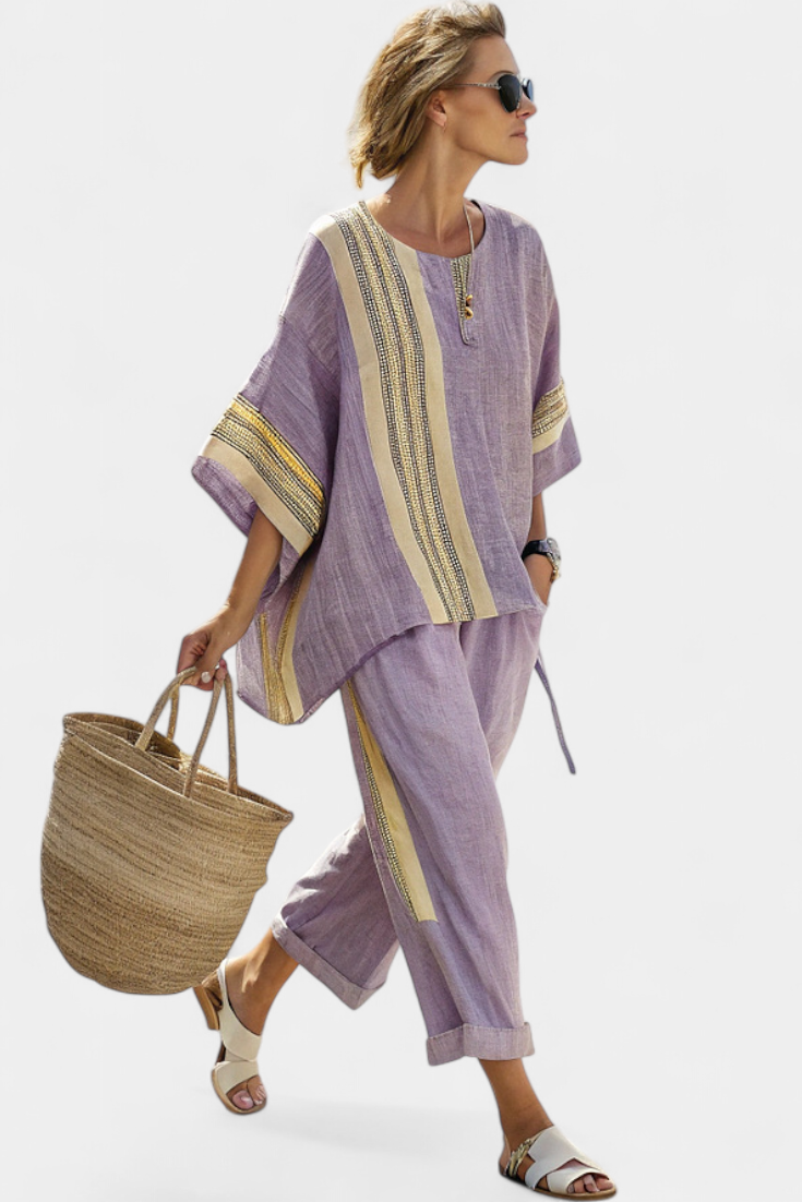 Women’s two-piece outfit featuring an asymmetrical blouse with embroidery and relaxed wide-leg pants designed for lightweight summer wear.