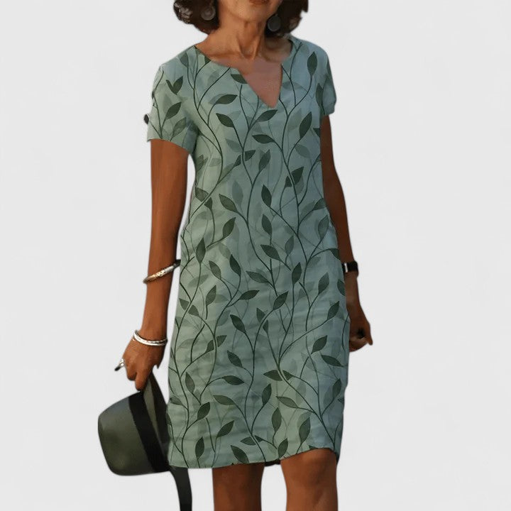 Women’s breathable cotton summer dress with notched V-neckline, soft leaf print, and relaxed waist fit for effortless style and comfort.
