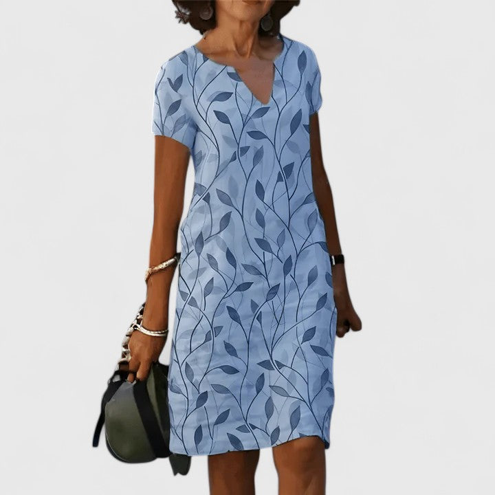 Women’s breathable cotton summer dress with notched V-neckline, soft leaf print, and relaxed waist fit for effortless style and comfort.