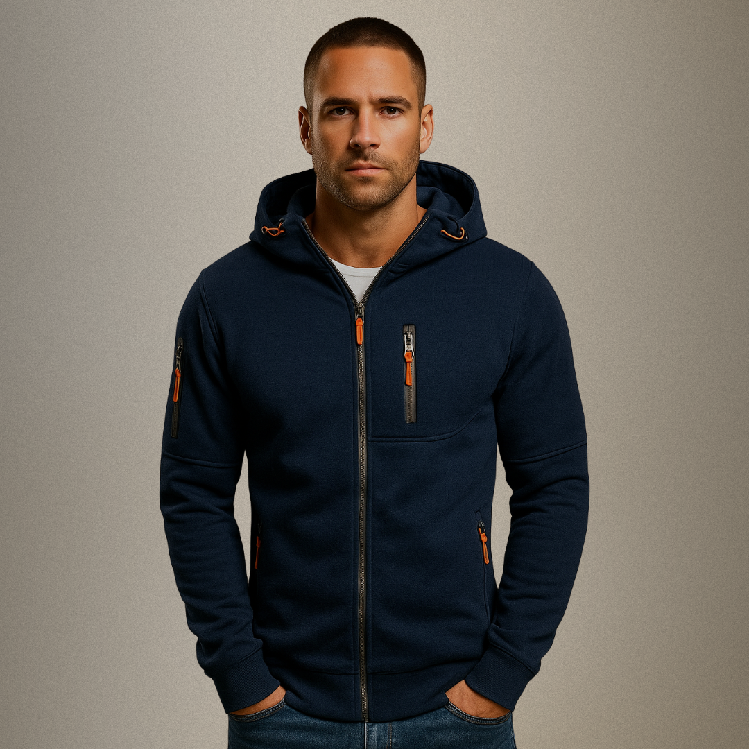 Man wearing a navy blue hoodie with orange accents on a beige background