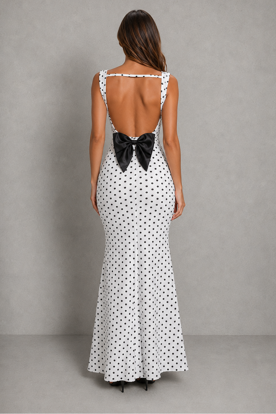 Women’s backless polka dot maxi dress with statement bow detail, sleeveless design, and flattering body-skimming silhouette.