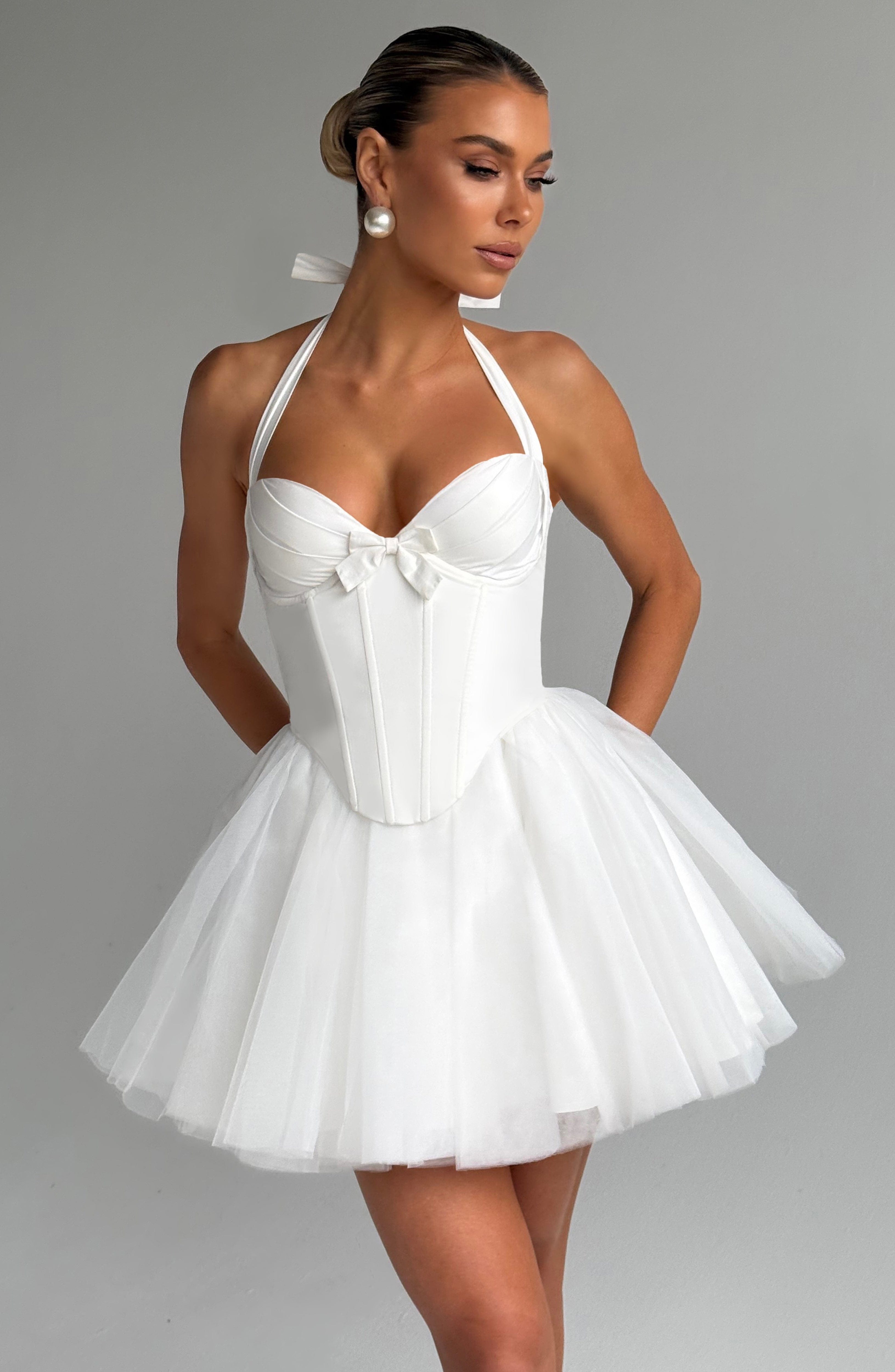 Women’s corset mini dress with sweetheart neckline, halter neck, lace-up back, fitted bodice, and voluminous tulle skirt.