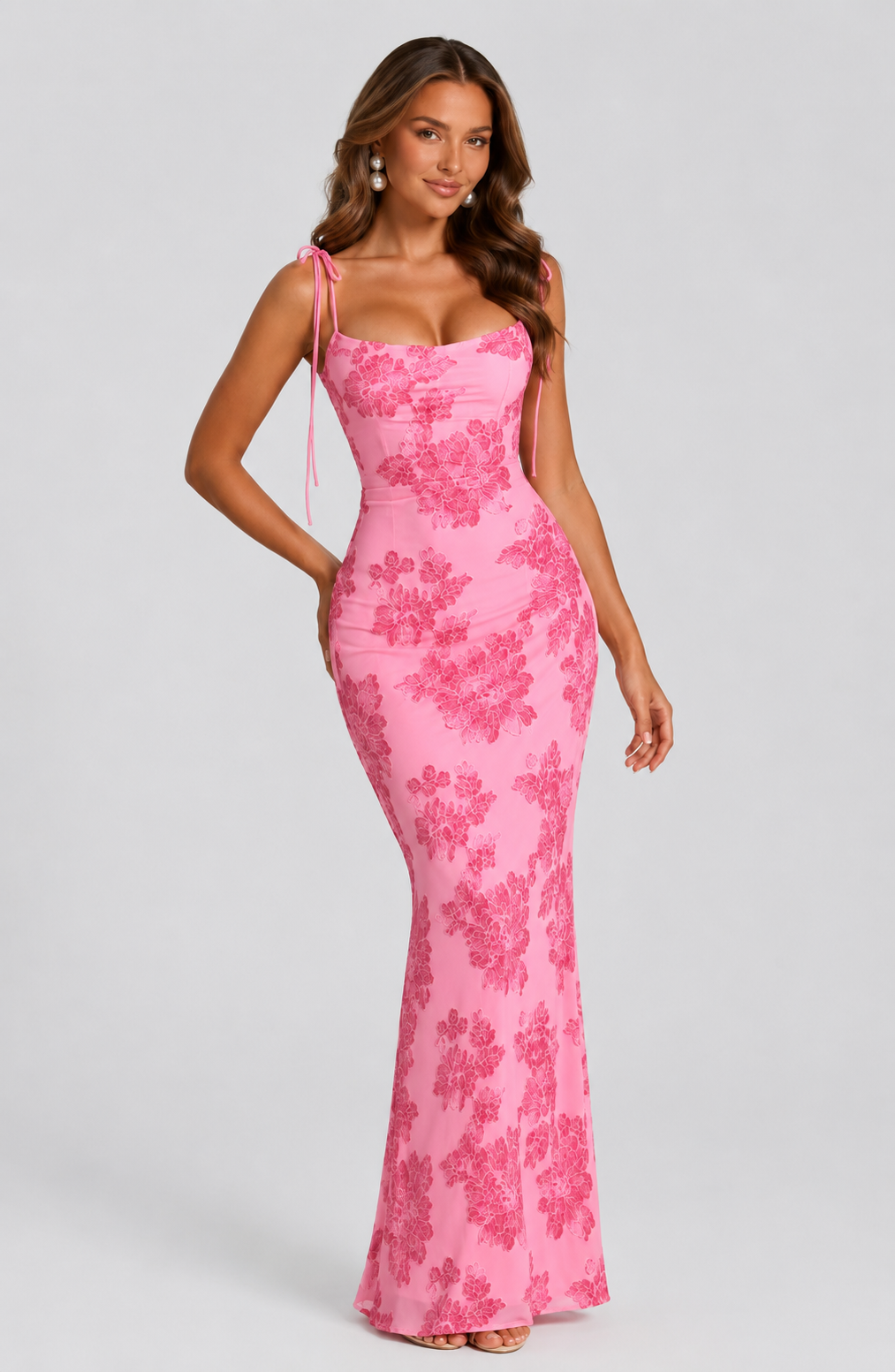 Woman wearing a pink floral dress against a plain background