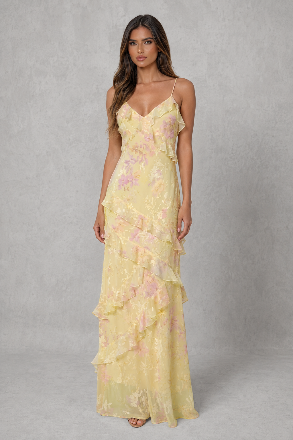 Women's floral chiffon maxi dress with a V-neckline, adjustable shoulder straps, soft pastel floral print, cascading ruffle details, and a flowing figure-flattering silhouette, ideal for wedding guests and special occasions.