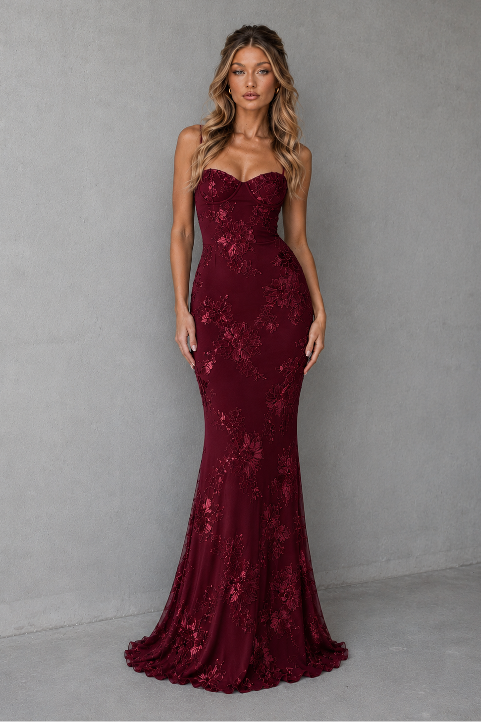 Woman wearing a women's floral embroidered corset maxi dress with a fitted bodice, delicate shoulder straps, defined waist, and flowing full-length skirt, designed for weddings, formal events, and special occasions.
