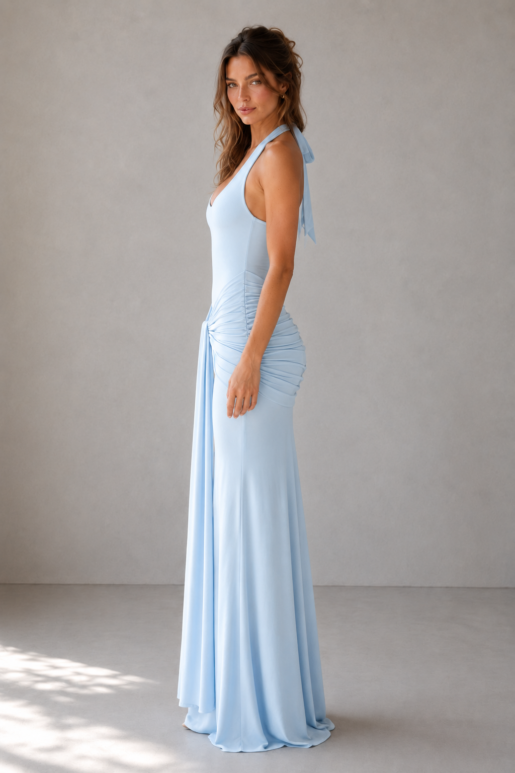 Women’s halter maxi dress in soft modal jersey featuring a plunging neckline, adjustable halter ties, body-contouring fit, wide ruched draped hip panel, and centre-front tie detail, designed for elegant evening and formal occasions.