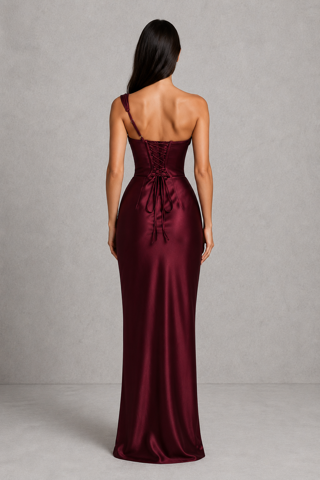 Woman wearing a one-shoulder satin maxi dress featuring a pleated cowl neckline, structured corset bodice with boning, asymmetrical draping, adjustable lace-up back, and a flowing bias-cut skirt, ideal for formal events, evening occasions, and special celebrations.