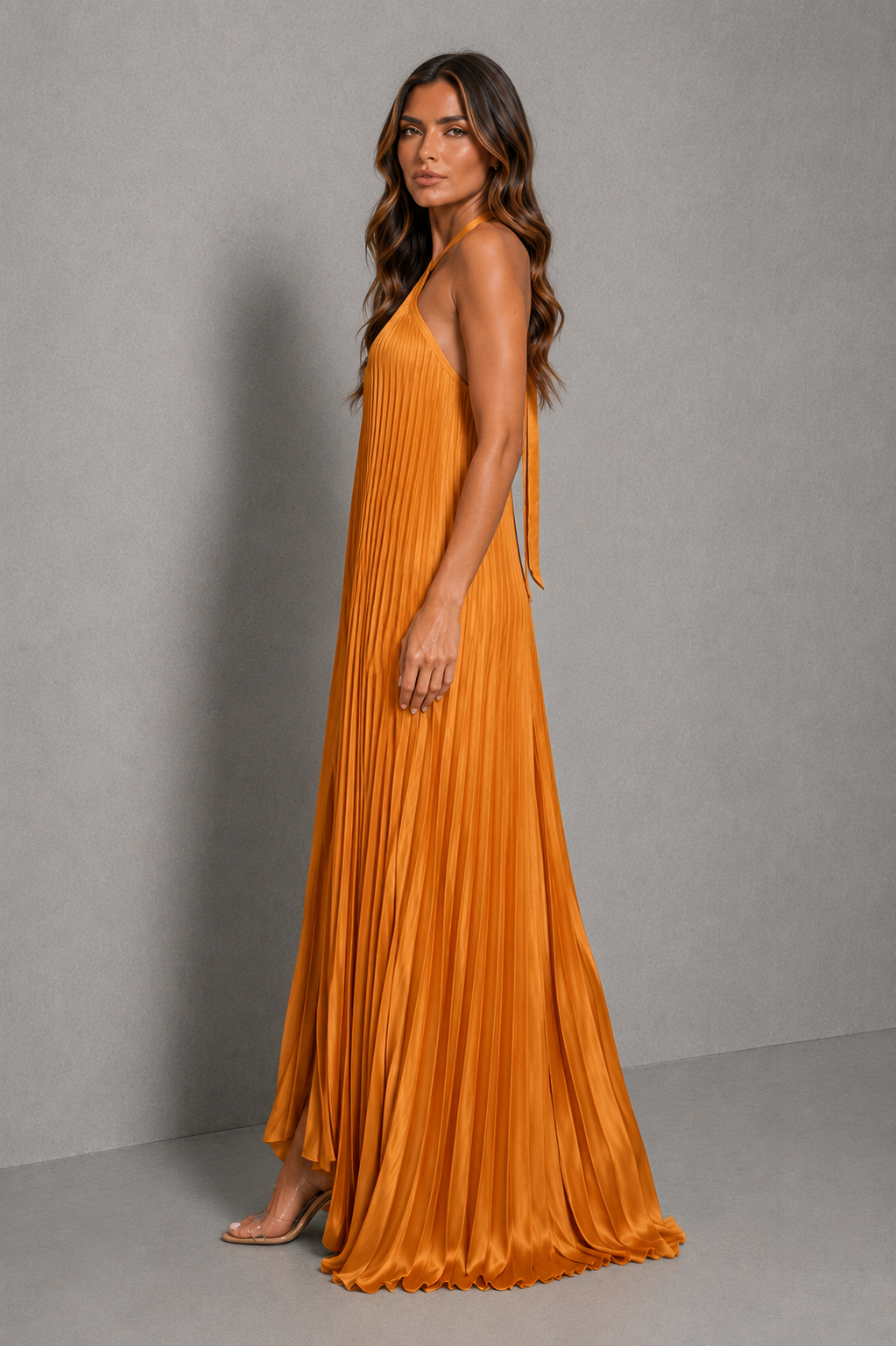 Women's pleated halterneck maxi dress with a cross-front neckline, open back with adjustable tie fastening, and flowing floor-length pleated skirt, ideal for wedding guests, formal occasions, and evening wear.