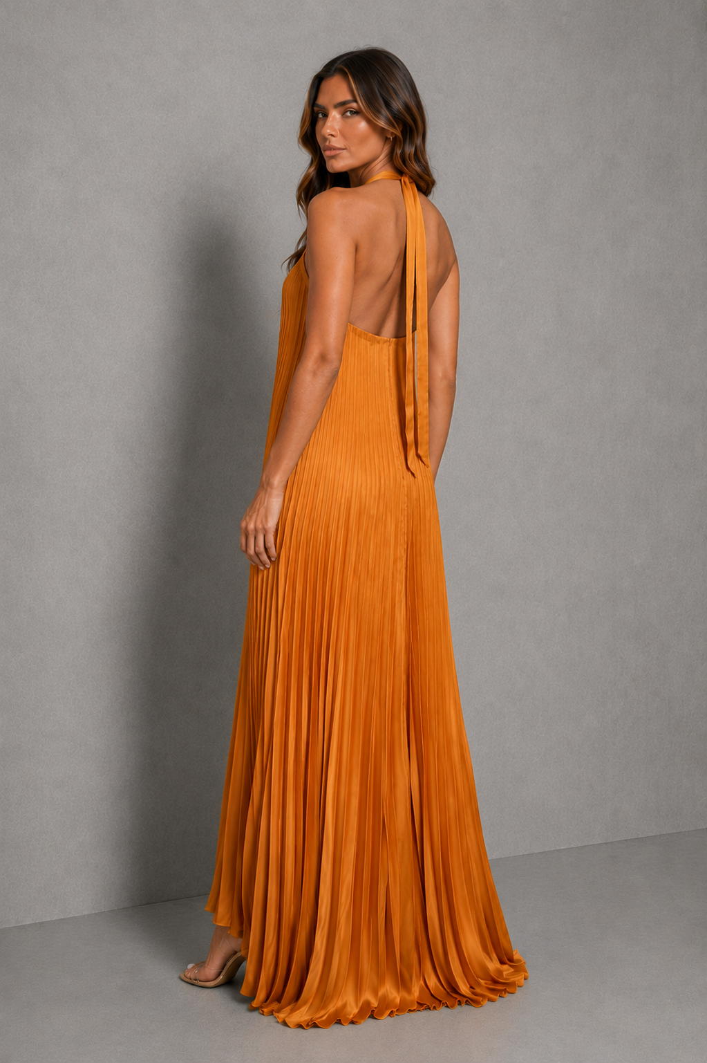 Women's pleated halterneck maxi dress with a cross-front neckline, open back with adjustable tie fastening, and flowing floor-length pleated skirt, ideal for wedding guests, formal occasions, and evening wear.
