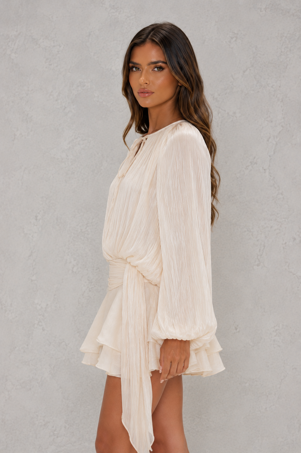 Women’s pearl pleated long sleeve mini dress with twist-front draping, neck tie, structured shoulders, and ruffled hem.