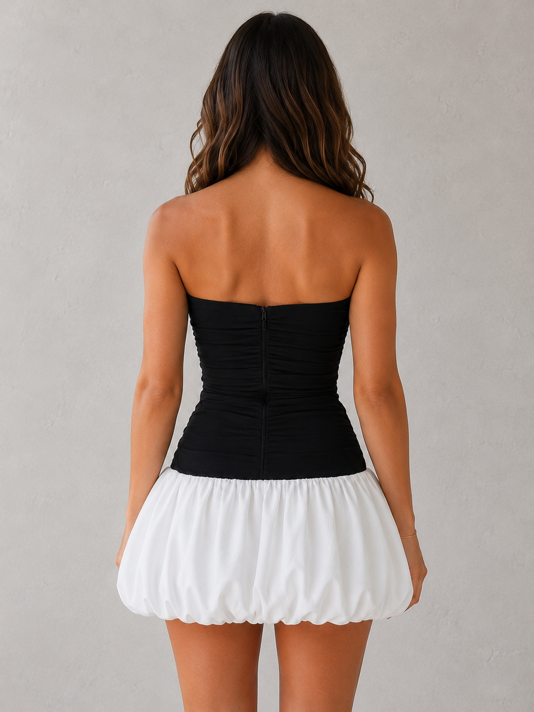 Women's strapless stretch crepe mini dress with a fitted pleated bodice, dropped waist, and voluminous puffball skirt, designed for parties, cocktail events, and special occasions.