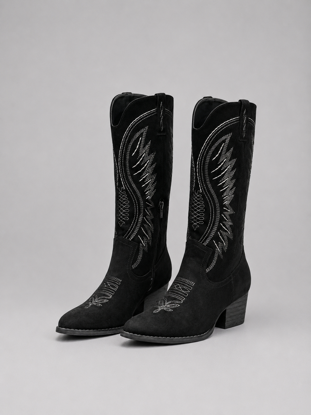 Women’s knee-high suede cowboy boots with western stitching, pointed toe, mid block heel, and classic pull-on design.