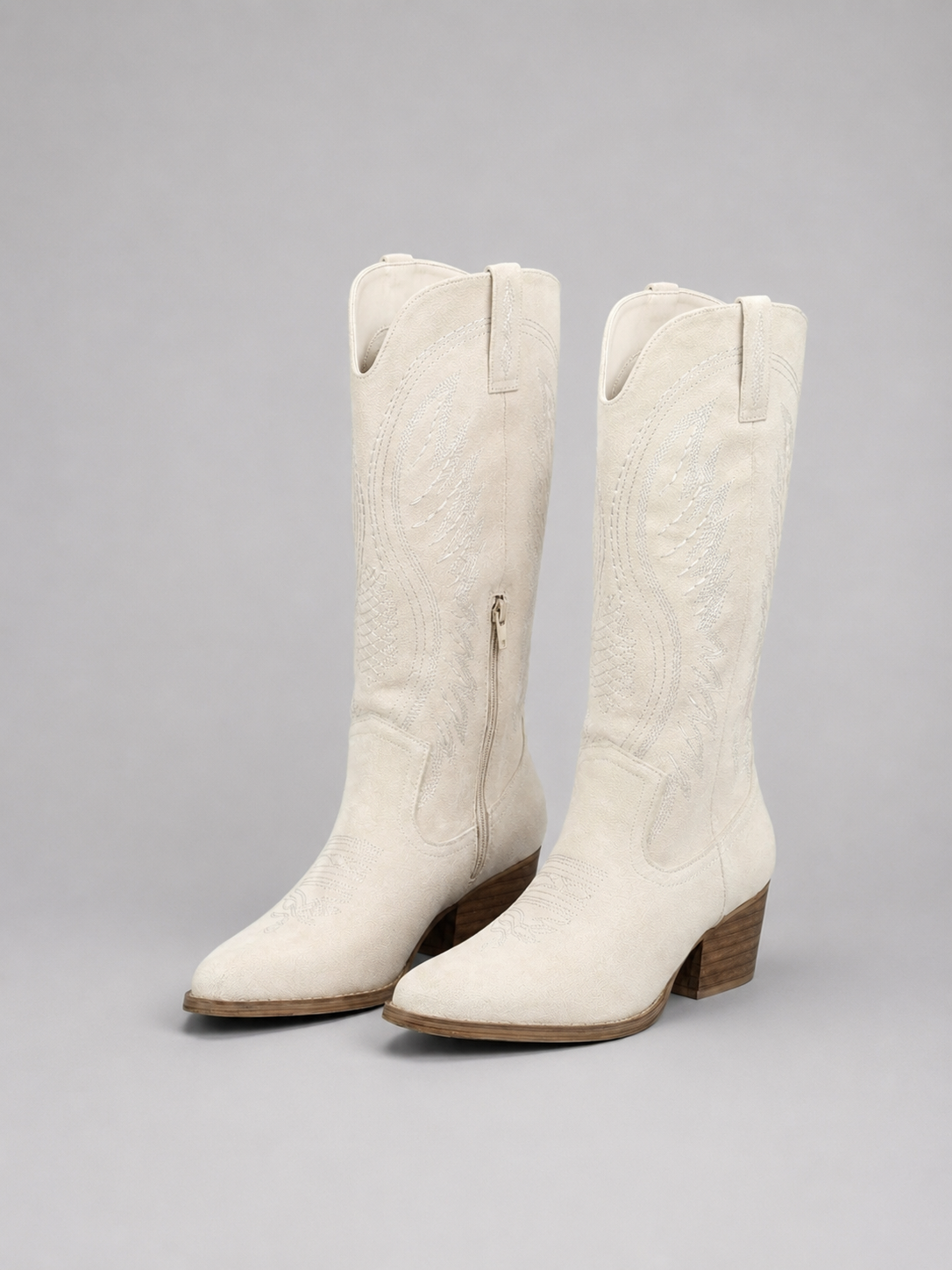 Women’s knee-high suede cowboy boots with western stitching, pointed toe, mid block heel, and classic pull-on design.