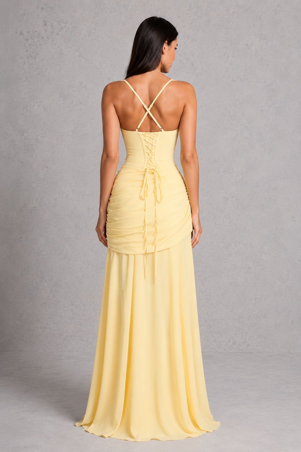 Women’s chiffon maxi dress with a twist cowl neckline, crossover straps, asymmetric pleating, flowing godet skirt and lace-up back.