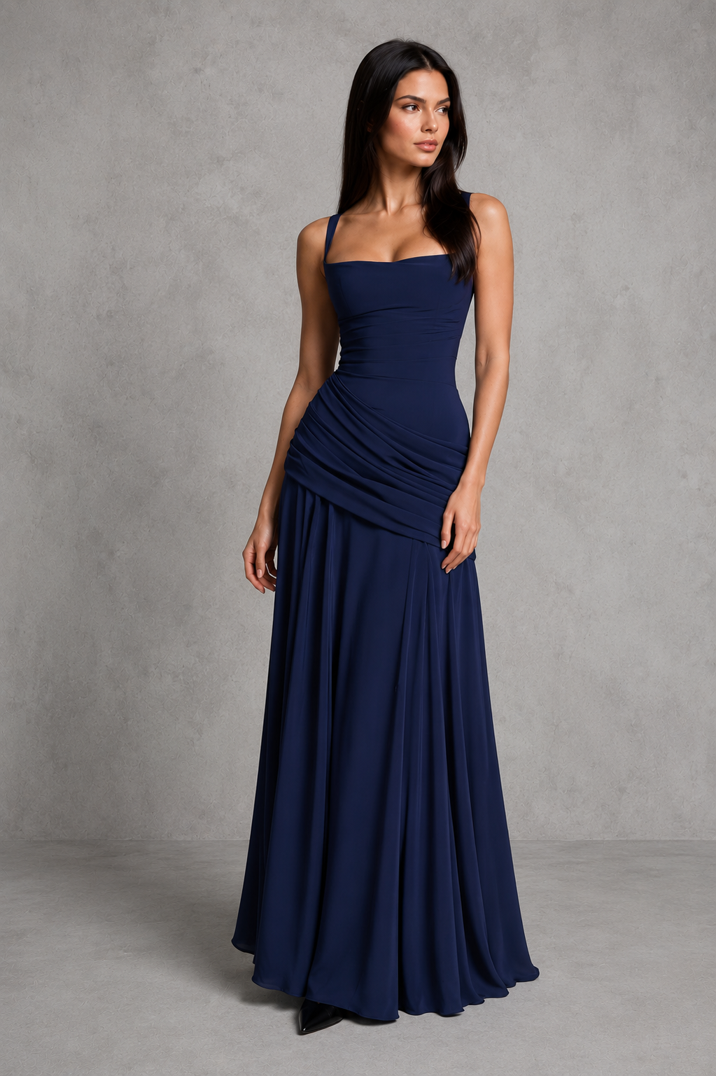 Women’s chiffon maxi dress with a twist cowl neckline, crossover straps, asymmetric pleating, flowing godet skirt and lace-up back.